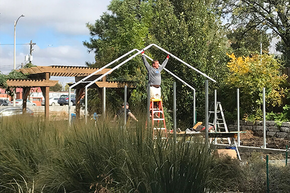 Construction of a new home frame in progress in Lincoln, Nebraska. Home builders are assembling the roof structure with ladders and tools. c9598517 224a 4388 90e7 12edf2011b3b