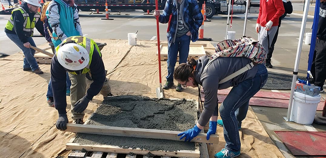 Students learning concrete leveling techniques in an outdoor hands-on session.