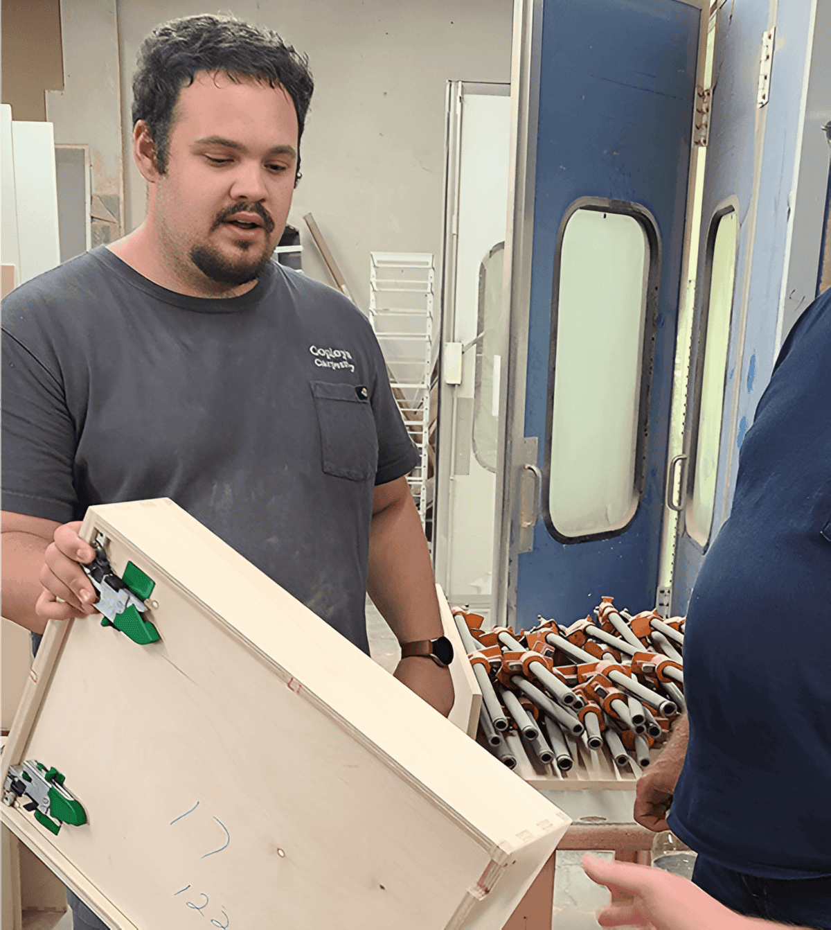 Man from Cogsdon Carpentry holding a wooden drawer box.