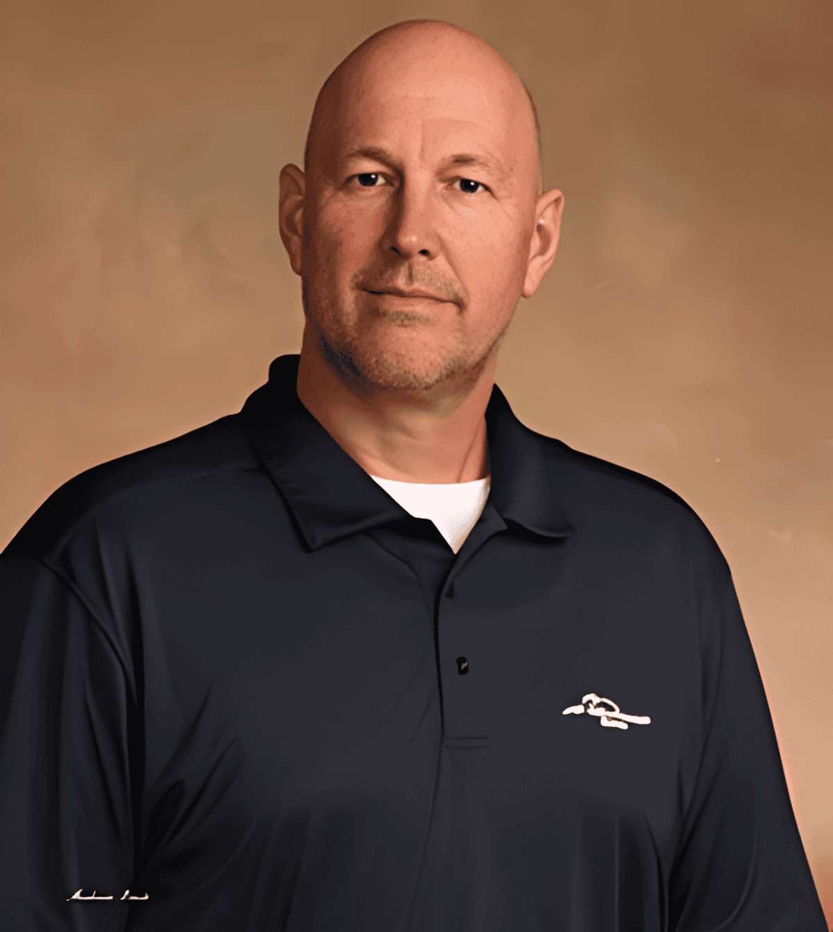 Portrait of a man in a black polo shirt with a logo, neutral background.