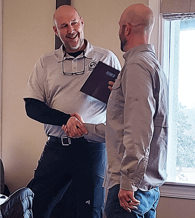 Two men shaking hands at a professional event during the 2022 Remodelers Holiday Party.