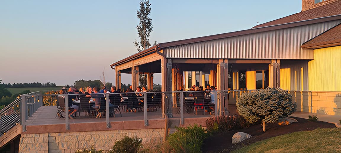 People gathered on a patio at sunset during the 2023 Autumn Social event.