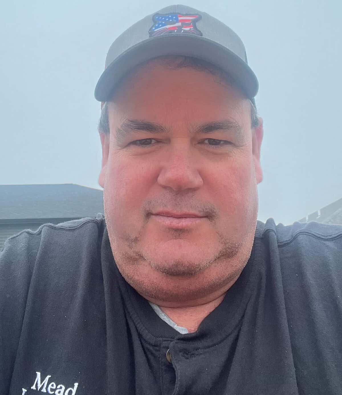 Man wearing a cap and black shirt outdoors in Lincoln, Nebraska.