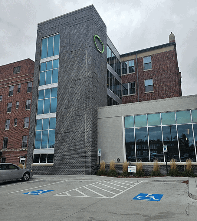 Modern multi-story building with glass windows and brick facade in Lincoln, Nebraska.