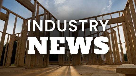 Construction site with wooden framing for a new building under a cloudy sky.