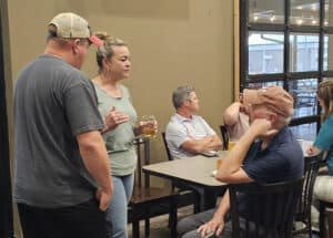 Group of people socializing at a bar during the Autumn Social event.