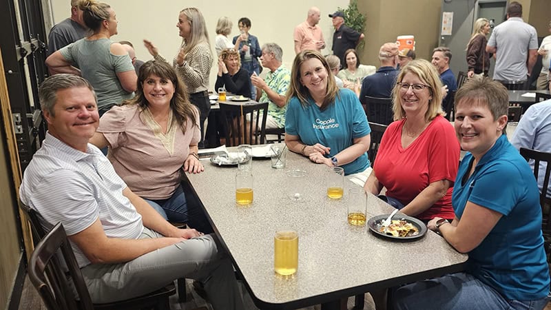 Group of people enjoying food and drinks at Autumn Social event.