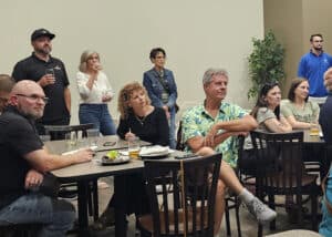 Group of people watching a presentation at the 2025 Autumn Social event.